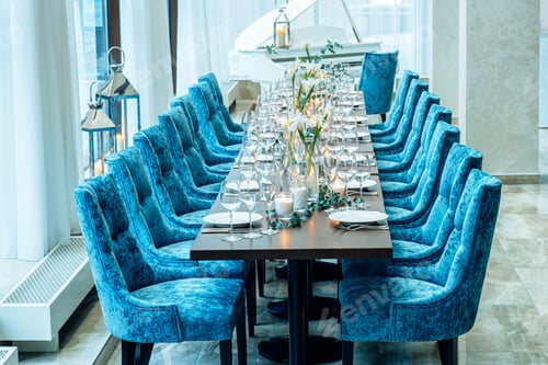 Preview: Table setting. On the banquet table there are plates with napkins and name cards, glasses and cutler