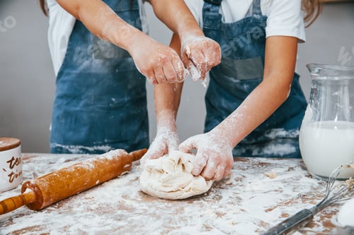 Preview: Close up view of two little girls in blue chef uniform that preparing food on the kitchen