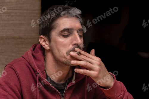 Preview: Man smoking medical cannabis joint while relaxing and relieving stress