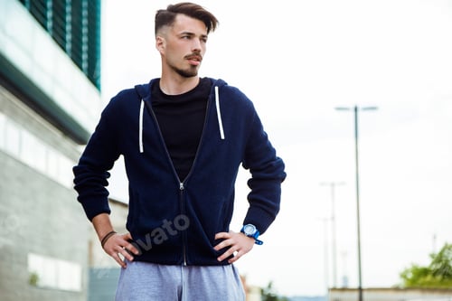 Preview: Young man resting after running in the street.