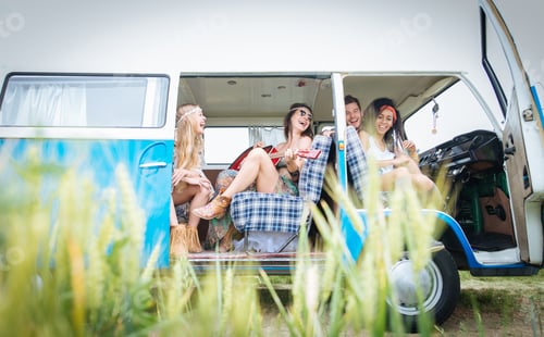 Preview: Happy friends driving a vintage minivan