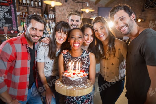 Preview: Portrait of happy friends holding birthday cake