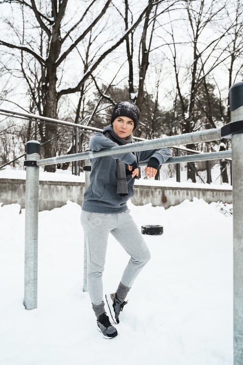 Preview: Athletic woman during her winter outdoor workout on parallel bars