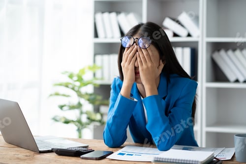 Preview: Asian tired business woman feeling overwhelmed and desperate after a long day at work.