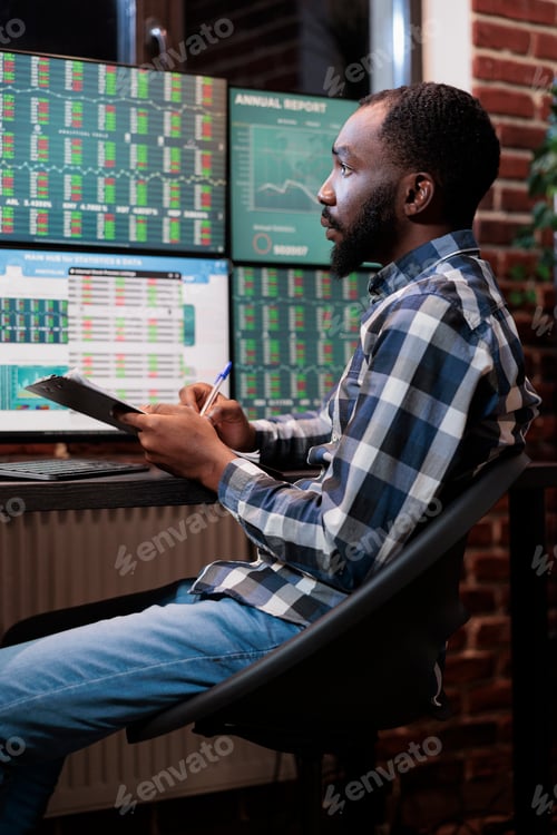 Preview: Real time financial data analyst sitting at multi monitor workstation while predicting market trend.