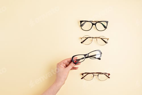 Preview: Woman hand holding eyeglasses. Optical store, glasses selection, eye test, vision examination