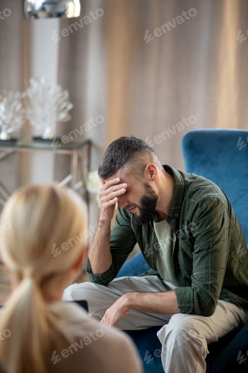 Preview: Dark-haired man talking about depression to psychologist