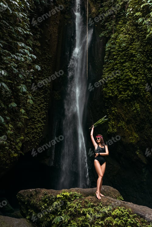 Preview: Beautiful girl at a waterfall on the island of Bali Indonesia. Sexy woman at the waterfall