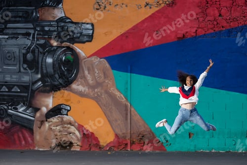 Visualização: Mulher super animada pulando contra o grafite