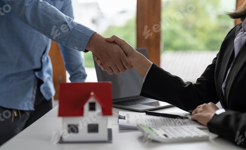 Preview: Real estate agents and customers shake hands to congratulate on signing a contract to buy a house