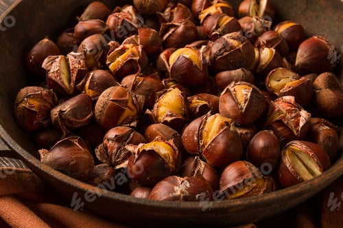 Preview: Roasted chestnuts, in an iron pan, wooden table, top view, no people, rustic style,