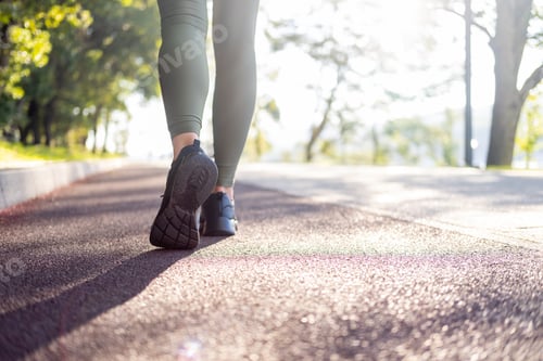Preview: close up woman legs in sport sneakers running in park on sunrise time. Healthy fitness lifestyle