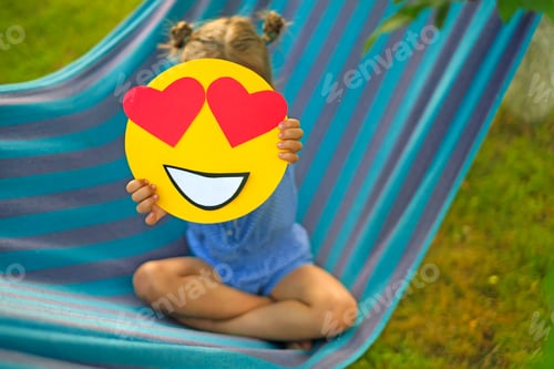 Preview: Lady shows close-up of emoticon with heart-shaped eyes on eve of World emoji Day