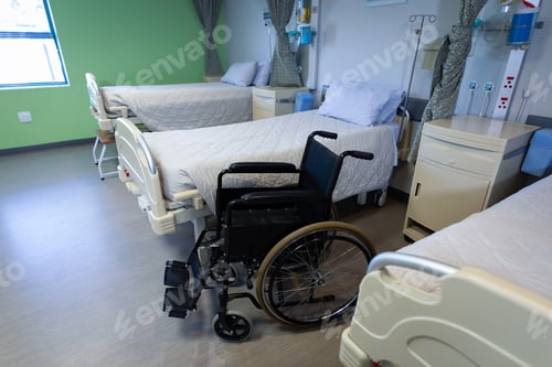 Preview: Front view of row of empty hospital beds and wheelchair in hospital