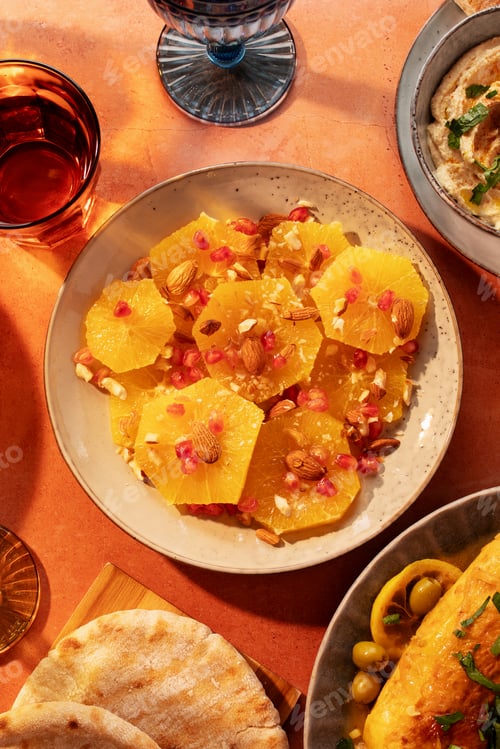 Preview: Moroccan oranges and pomegranate salad on table with traditional arabic dishes