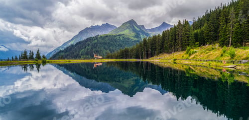 Preview: Alpine lake surrounded by green trees and mountains. Silvretta High Alpine Road, Switzerland.