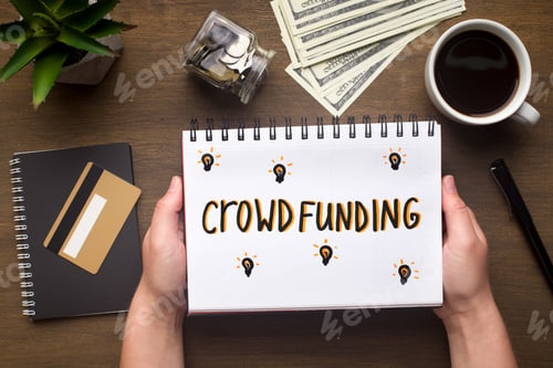 Preview: Notepad with crowdfunding concept in woman hands