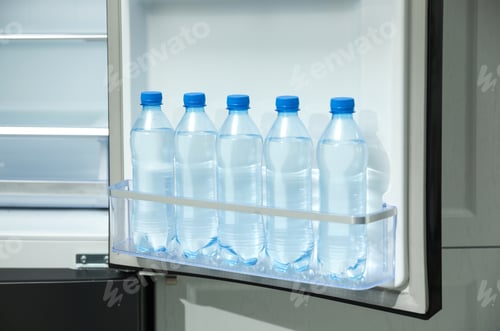 Preview: Many bottles with fresh water in fridge door bin