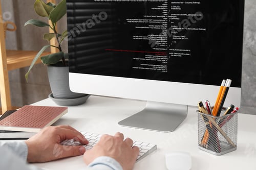 Preview: Programmer working with computer at white desk in office, closeup