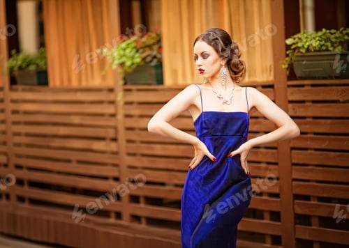 Preview: Beautiful young woman wearing a violet dress walking and posing