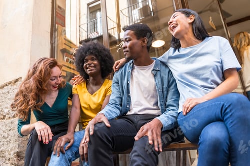 Preview: Multi-ethnic friends in a coffee shop sitting in the doorway the shop window, embracing each other