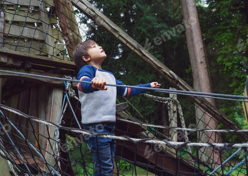 Preview: Kid climbing on tree house on playground, Young boy playing adventure in outdoor playground