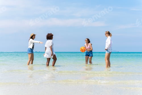 Preview: group of girls of different ethnicities running and having fun together at beach