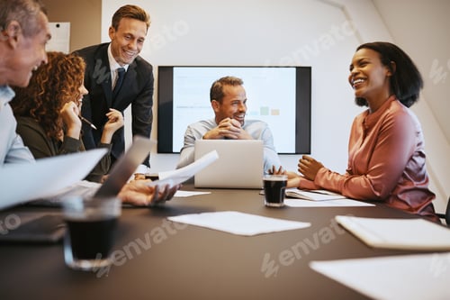 Preview: Group of smiling businesspeople discussing work together during a meeting