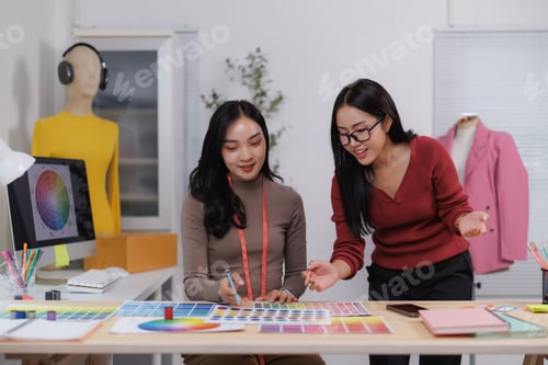 Preview: Fashion designers choosing colors for new clothes collection using palette
