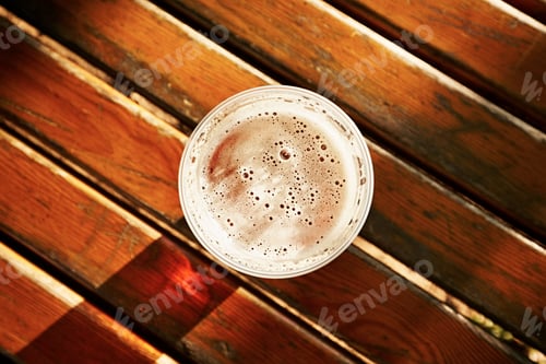 Refreshing Beer with Foam on Wood Table