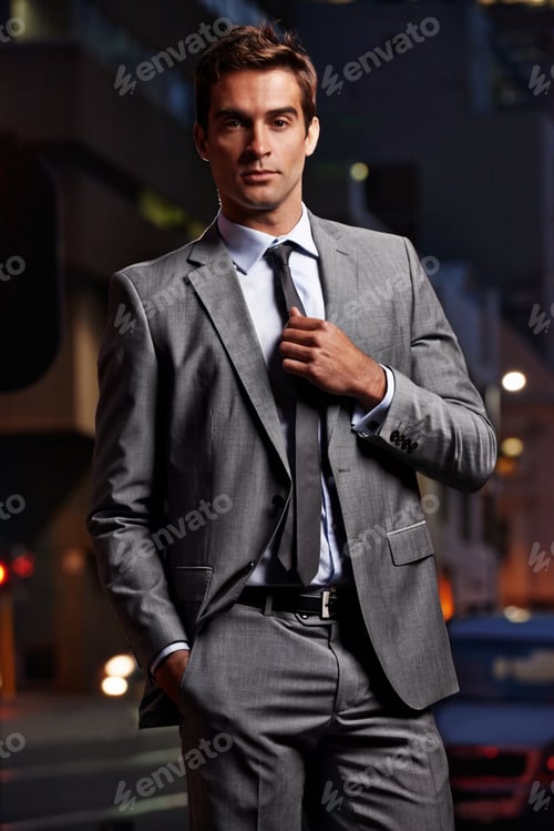 Preview: Portrait of a handsome businessman in a suit standing in a city setting at night
