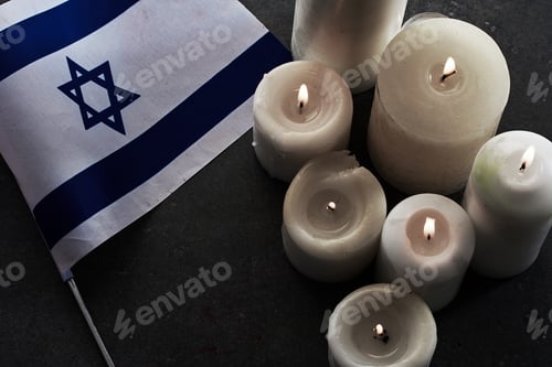 Preview: Burning candles and flag of Israel on dark background. Holocaust remembrance day