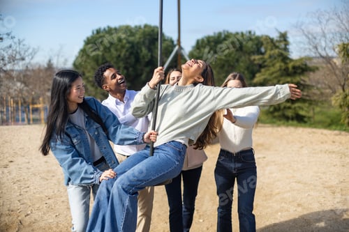 Preview: Young people having fun on a swing in a playground