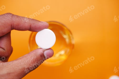 Preview: Effervescent soluble tablet pills and glass of water on purple background