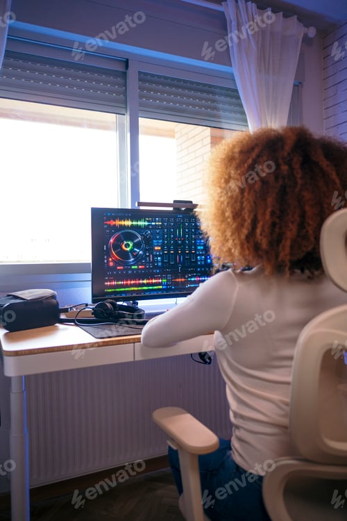 Preview: Woman producing music using dj software on computer at home studio