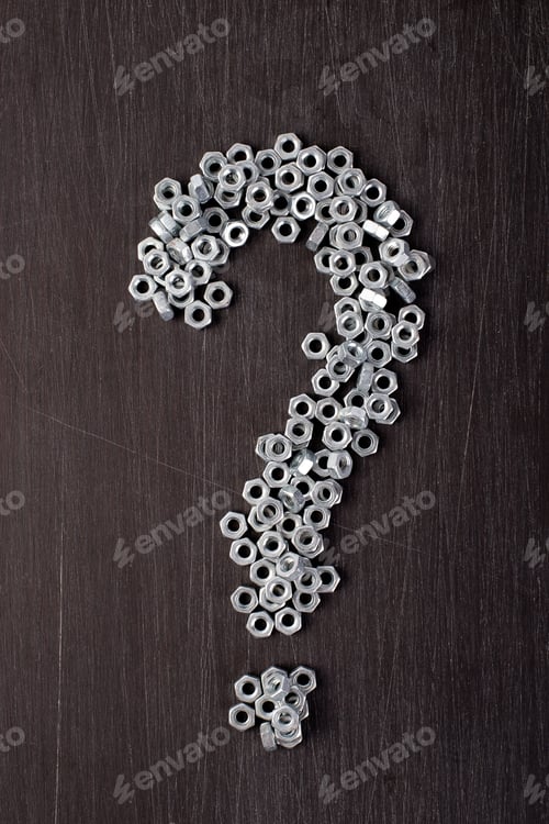 Preview: Sign question from metal nuts background. Flat lay.