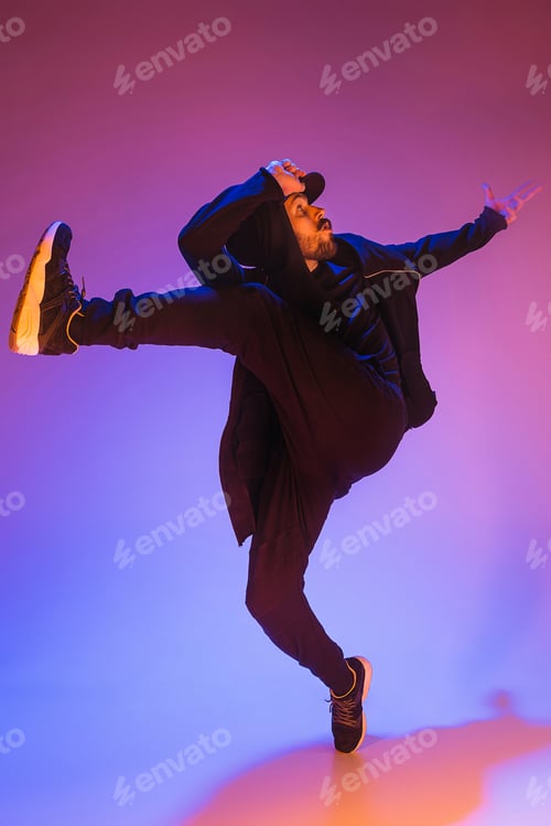 Preview: The silhouette of one hip hop male break dancer dancing on colorful background