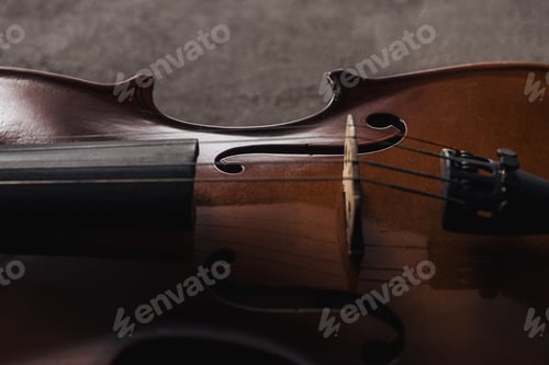 Preview: close up of strings on classical wooden cello on grey textured background