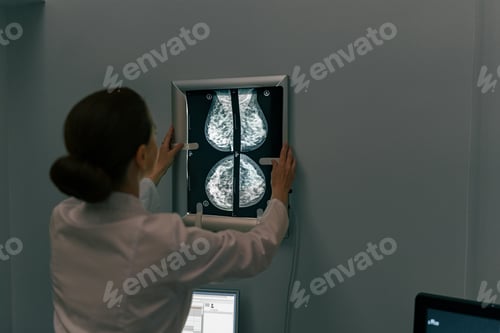 Preview: Back view of professional doctor radiologist looking on scan MRI images in medical center