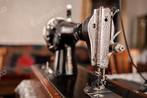 Preview: Old sewing machine stands on the table at home ready to work and sew.
