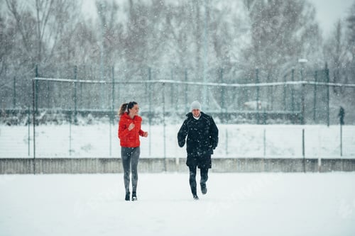 Preview: Young couple going for a run together during a snow