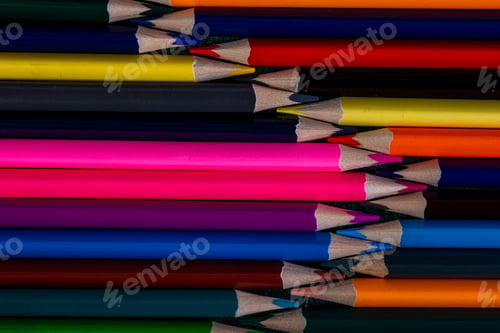 Preview: top view of colored pencils arranged on dark background