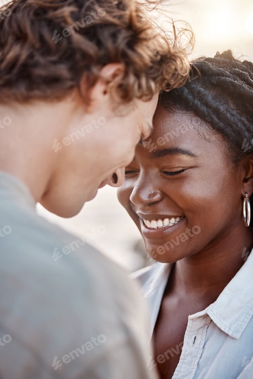 Preview: A young mixed race couple enjoying a day at the beach looking happy and in love