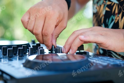 Preview: DJ Hands creating and regulating music on dj console mixer in beach club stage