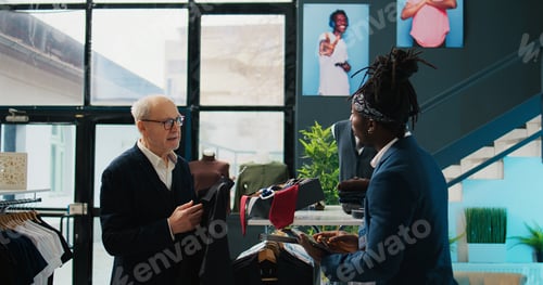 Preview: Regular elderly client asking store worker for assistance with clothing items