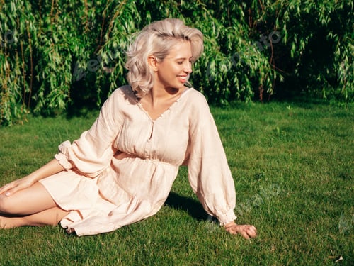 Preview: Young beautiful smiling blond woman posing outdoors