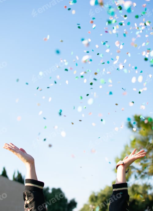 Preview: Beautiful happy woman at celebration party with confetti falling everywhere on her