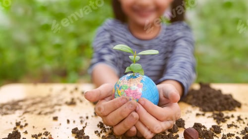 Preview: Banner of blurred little girl is holding plant and globe model together, concept of ESG.
