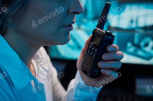 Preview: Middle Aged Caucasian Woman Using Walkie Talkie While Monitoring Security Screens