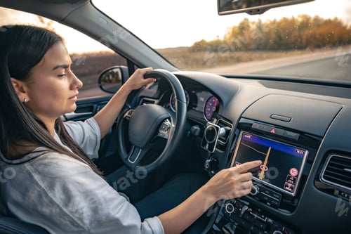 Preview: Woman using navigation system while driving a car.